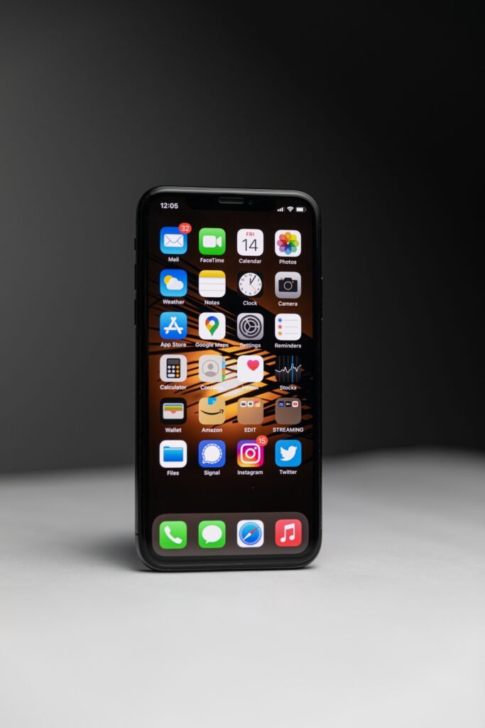 Close-up of a smartphone with an array of app icons against dark background.