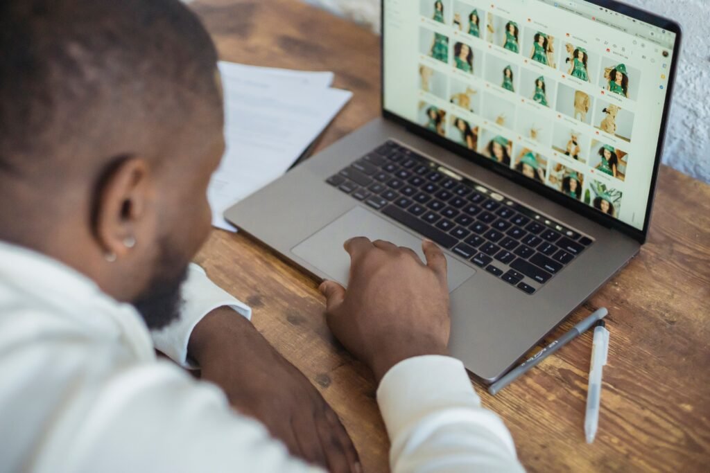 High angle of crop bearded African American male entrepreneur working on netbook sitting at table